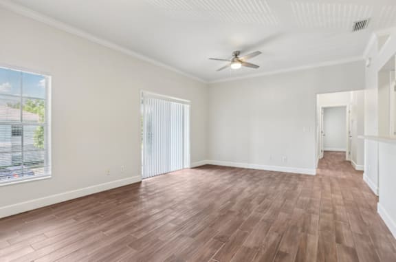 A room with wooden flooring and a ceiling fan.